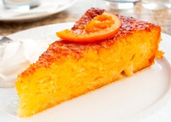 Bolo de laranja húmido e fofo da avó acabado de fazer, com cobertura brilhante e textura macia.