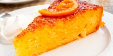 Bolo de laranja húmido e fofo da avó acabado de fazer, com cobertura brilhante e textura macia.