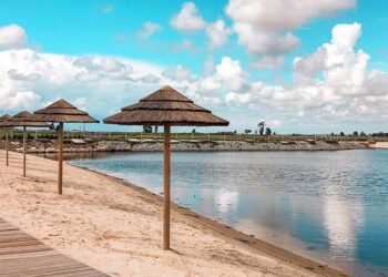 uma praia com água a 25 graus