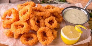 Aprenda a fazer Calamares Fritos à Andaluza! Deliciosos anéis de lula macios e crocantes, fritos com perfeição e servidos com uma pitada de limão.