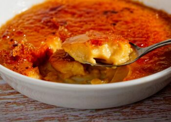 Leite creme caseiro à moda antiga com açúcar queimado por cima, servido em taça rústica e com textura cremosa.