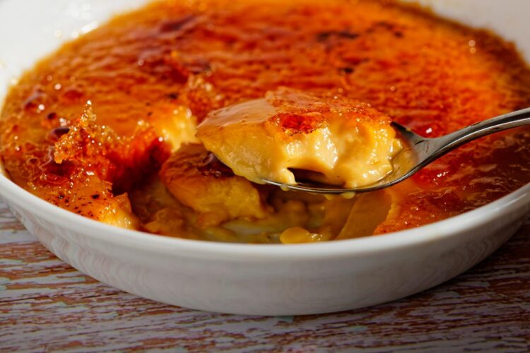 Leite creme caseiro à moda antiga com açúcar queimado por cima, servido em taça rústica e com textura cremosa.