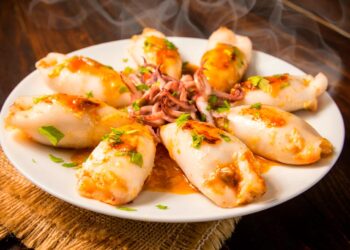 Lulas recheadas à moda antiga servidas num prato fundo com molho caseiro, receita tradicional portuguesa.