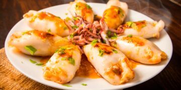 Lulas recheadas à moda antiga servidas num prato fundo com molho caseiro, receita tradicional portuguesa.