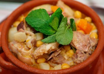 Cozido de grão à alentejana tradicional servido numa terrina rústica com carnes, enchidos e legumes.