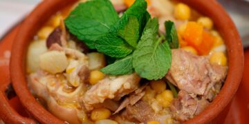 Cozido de grão à alentejana tradicional servido numa terrina rústica com carnes, enchidos e legumes.