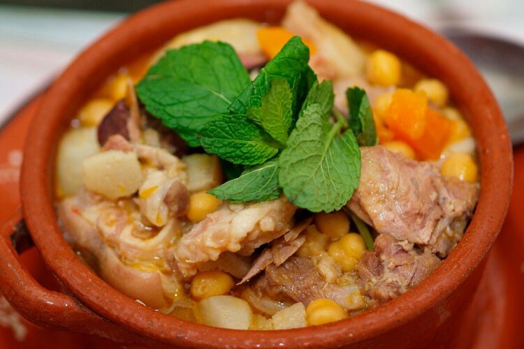 Cozido de grão à alentejana tradicional servido numa terrina rústica com carnes, enchidos e legumes.