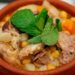 Cozido de grão à alentejana tradicional servido numa terrina rústica com carnes, enchidos e legumes.