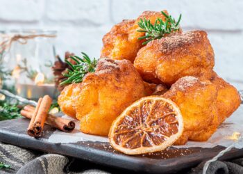Sonhos de abóbora caseiros, dourados e fofos, preparados no forno sem fritar, servidos polvilhados com açúcar e canela.