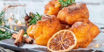 Sonhos de abóbora caseiros, dourados e fofos, preparados no forno sem fritar, servidos polvilhados com açúcar e canela.
