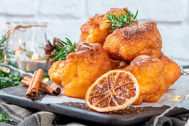Sonhos de abóbora caseiros, dourados e fofos, preparados no forno sem fritar, servidos polvilhados com açúcar e canela.