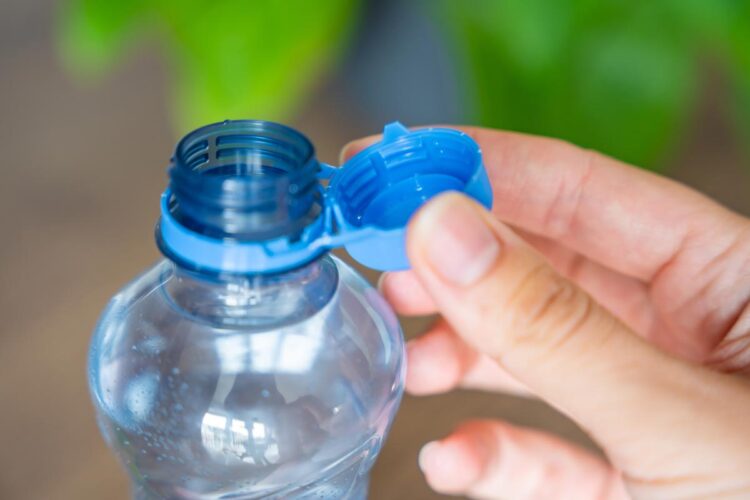Porque é que as garrafas de plástico têm as tampas presas?