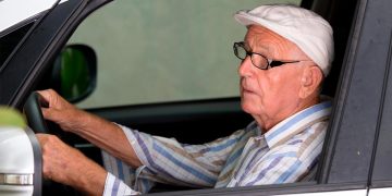 Condutor sénior ao volante, com atenção redobrada, ilustrando as regras de idade para condução em Portugal