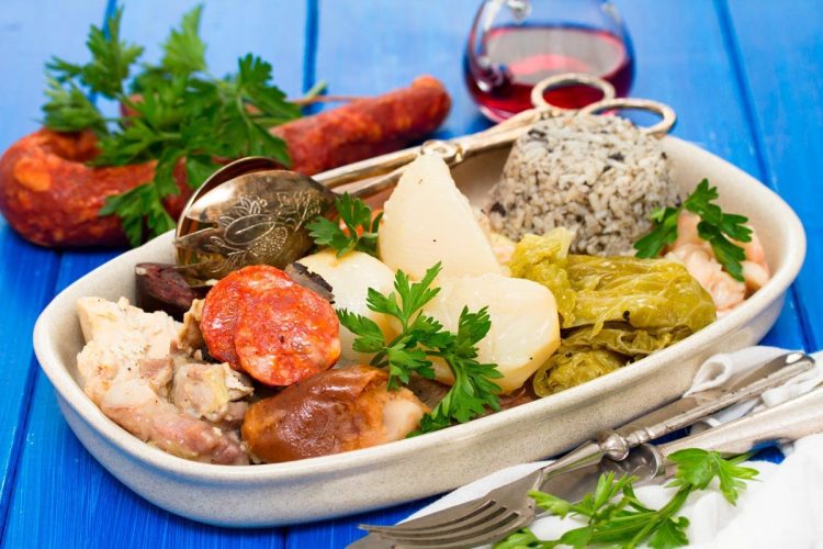 Cozido à Portuguesa Tradicional: receita autêntica e cheia de sabor Prato tradicional de Cozido à Portuguesa com carnes, enchidos, legumes e arroz numa travessa.
