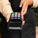 Utilizador a tapar o teclado de um terminal Multibanco ao introduzir o PIN