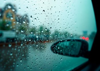 Condução à chuva com faróis médios ligados em estrada molhada