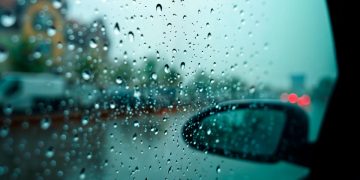 Condução à chuva com faróis médios ligados em estrada molhada