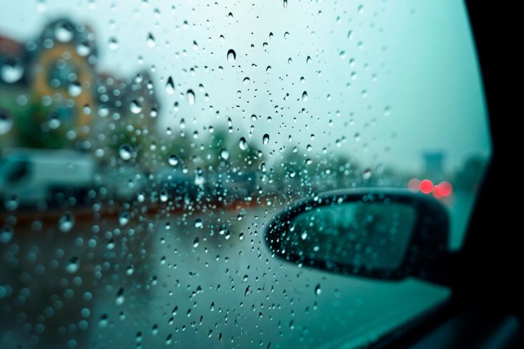 Condução à chuva com faróis médios ligados em estrada molhada