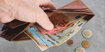 Filho a apoiar financeiramente mãe idosa, simbolizando o dever legal de assistência familiar em Portugal.