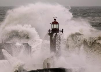 ondas gigantes a bater na costa portuguesa durante tempestade com céu escuro