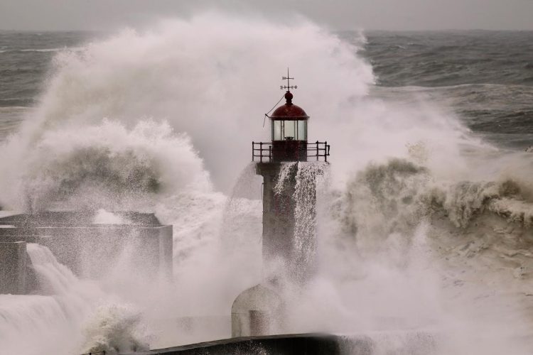 ondas gigantes a bater na costa portuguesa durante tempestade com céu escuro