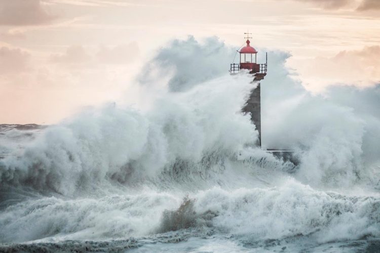 Ondas gigantes a bater na costa portuguesa sob céu escuro e vento forte