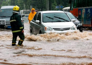 Nuvens negras e chuva intensa sobre cidade portuguesa após tempestade com ruas alagadas