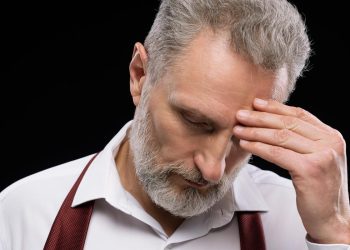 Trabalhador preocupado a consultar documentação sobre pensão e subsídio de desemprego