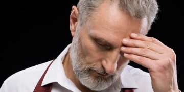 Trabalhador preocupado a consultar documentação sobre pensão e subsídio de desemprego