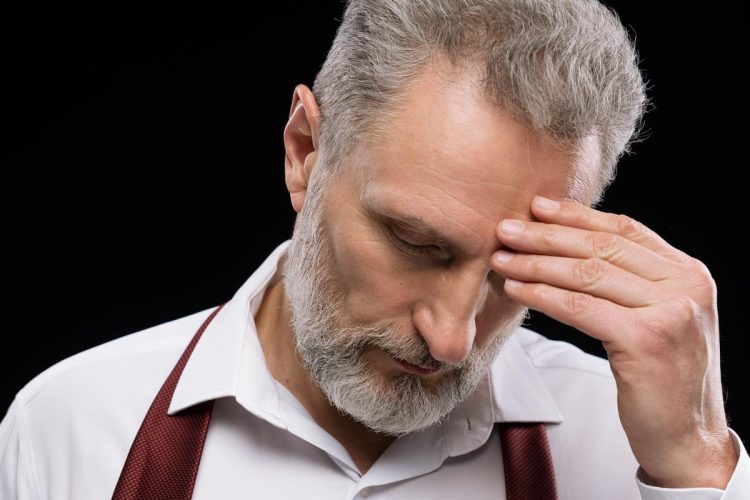 Trabalhador preocupado a consultar documentação sobre pensão e subsídio de desemprego