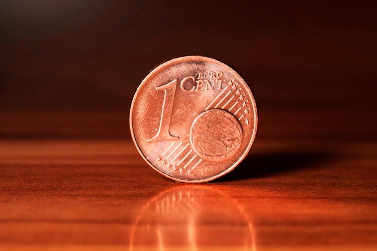 Moedas de 1 e 2 cêntimos espalhadas sobre mesa com carteira aberta e trocos acumulados